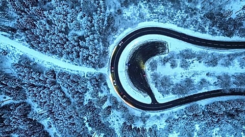 Cars drive around a curve in a snow covered forest of the Taunus region near Frankfurt, 6 January, 2026