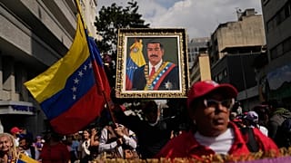 A government supporter holds an image of President Nicolás Maduro during a women's march to demand his return in Caracas, 6 January, 2026