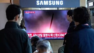 Uno schermo televisivo mostra un'immagine di repertorio del lancio missilistico della Corea del Nord durante un notiziario alla stazione ferroviaria di Seul, 22 ottobre 2025.