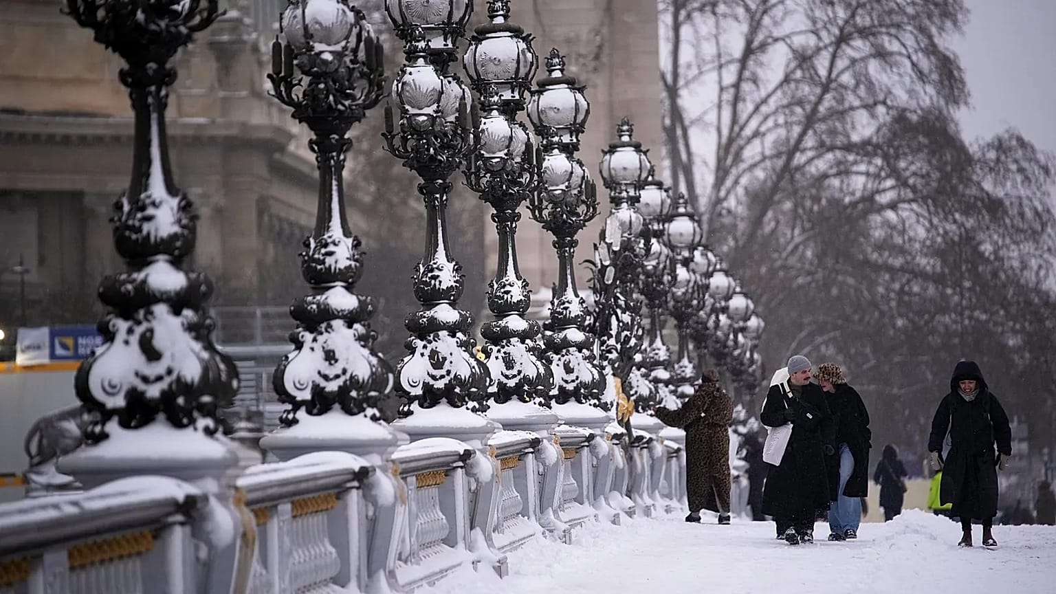 People walk on a bridge after a snowfall in Paris, 7 January, 2026 