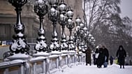 People walk on a bridge after a snowfall in Paris, 7 January, 2026 