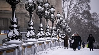 People walk on a bridge after a snowfall in Paris, 7 January, 2026 