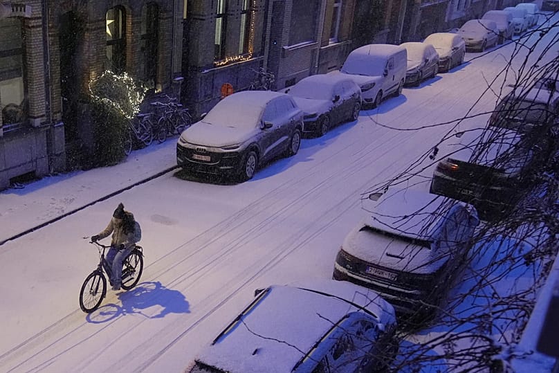 A cyclist rides down a street covered with snow in Antwerp, 7 January, 2026