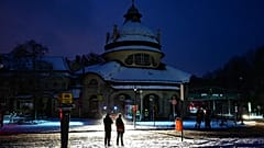 Passers-by stand in the light of a fire department help point in Berlin, 3 January, 2026