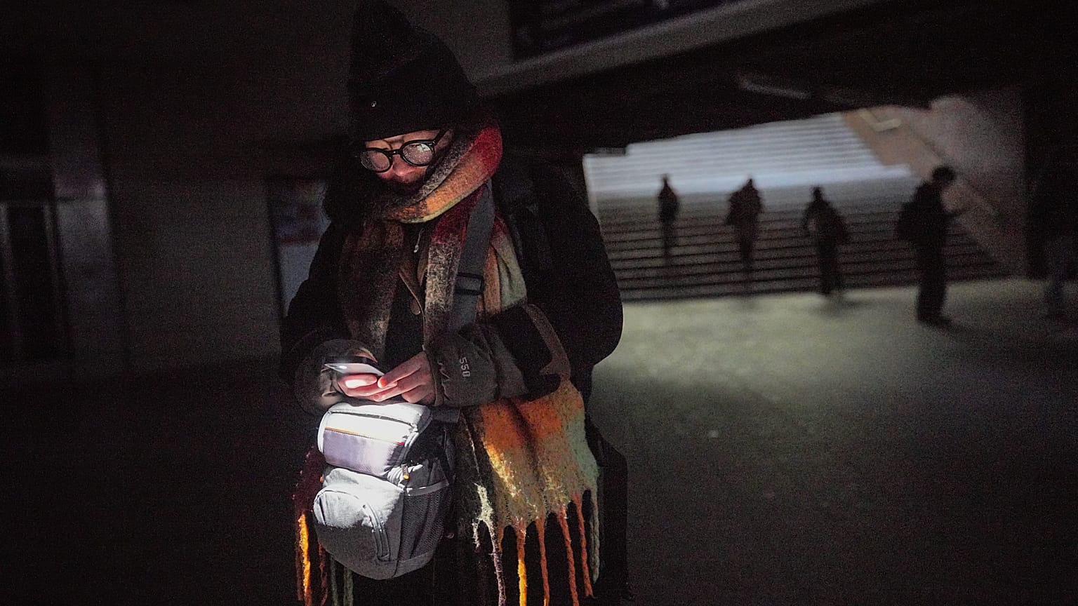 Bonnie usa la luz de su teléfono celular mientras camina por la estación de transporte público de Wannsee en Berlín, Alemania, el sábado 3 de enero de 2025.