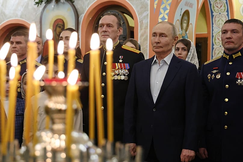 Le président russe Vladimir Poutine accompagné de militaires assistent à une messe orthodoxe de Noël près de Moscou