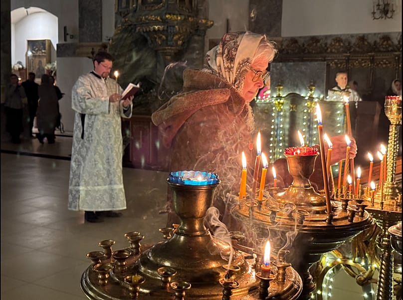 Os fiéis acendem velas diante das imagens sagradas