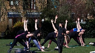 A goup of women exercise in a park in London.