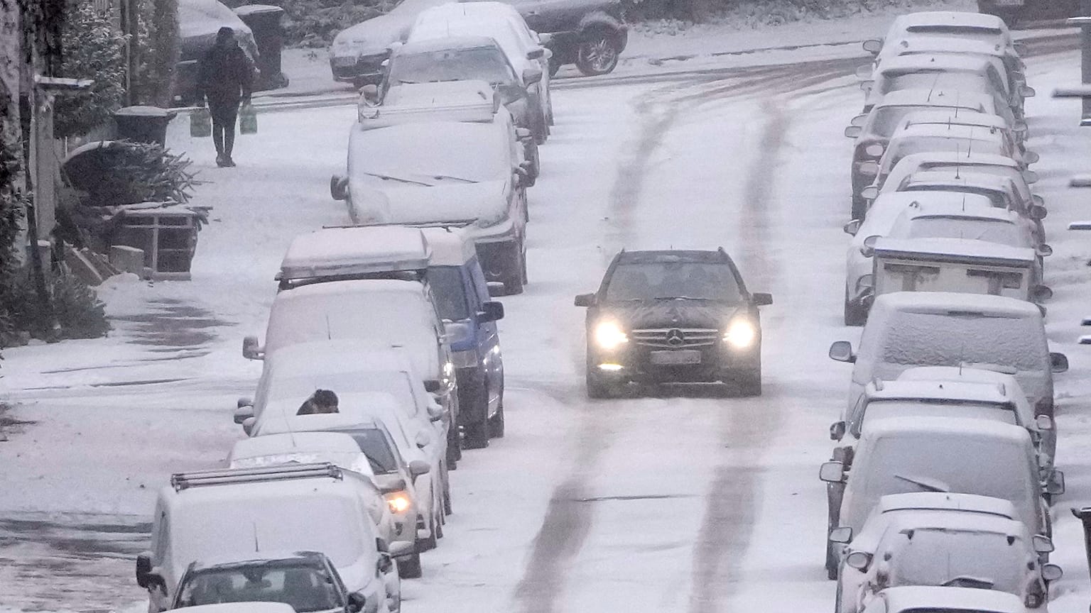 Ein Auto fährt vorsichtig über eine verschneite Straße in Gelsenkirchen im Ruhrgebiet während einer Kältewelle mit Schnee und Eis, Mittwoch, 7. Januar 2026.