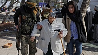 Suriye hükümet güçlerine bağlı bir asker, Halep'te bir sivile yardım ederken, 7 Ocak 2026