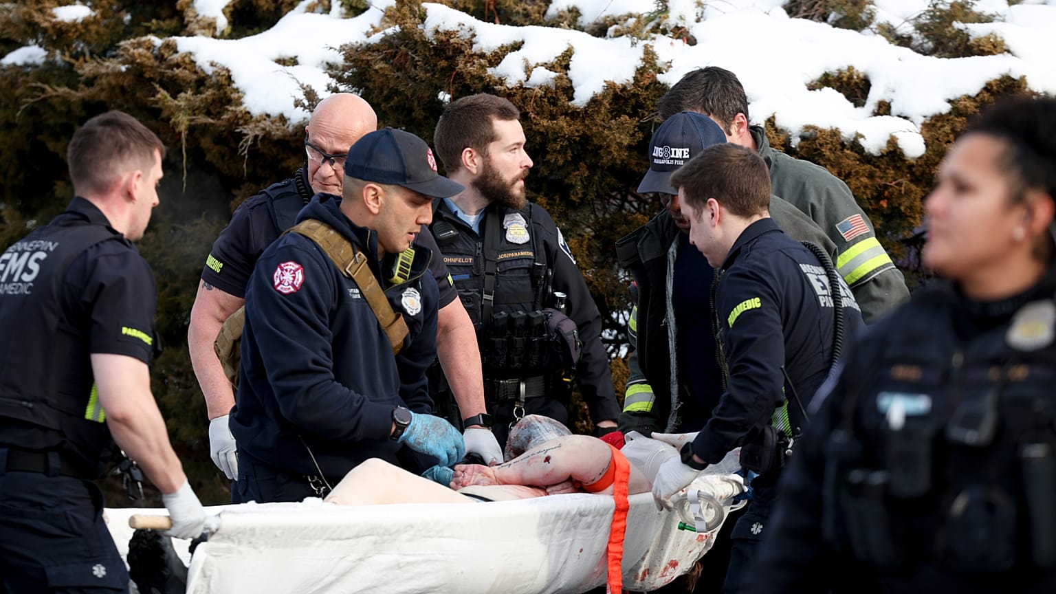 Emergency medical technicians administer aid to a person who was shot by a Immigration and Customs Enforcement officer in Minneapolis on Wednesday, Jan. 7, 2026.