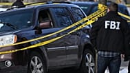 A bullet hole is seen in the windshield as law enforcement officers work the scene of a shooting involving federal law enforcement agents, Wednesday, Jan. 7, 2026, in Minneapo