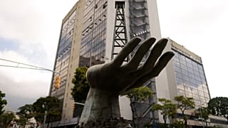 جسمه دستی که یک دکل حفاری نفت را در دست دارد، در بیرون شرکت نفت دولتی پترولئوس د ونزوئلا (PDVSA) در کاراکاس، ونزوئلا، ۲۱ مارس ۲۰۲۳