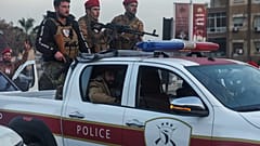 جنود من الجيش السوري يركبون مركبة خلال اشتباكات مع مقاتلين أكراد في منطقة متنازع عليها في مدينة حلب شمال سوريا،
