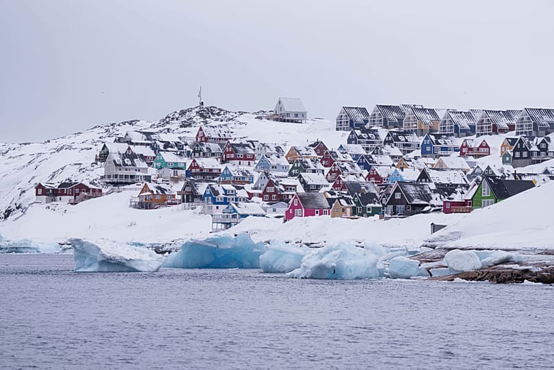Coloured houses covered by snow are seen from the sea in Nuuk, 6 March, 2025