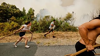 Varios residentes y voluntarios tratan de apagar un incendio en Larouco, Ourense, el 13 de agosto de 2026