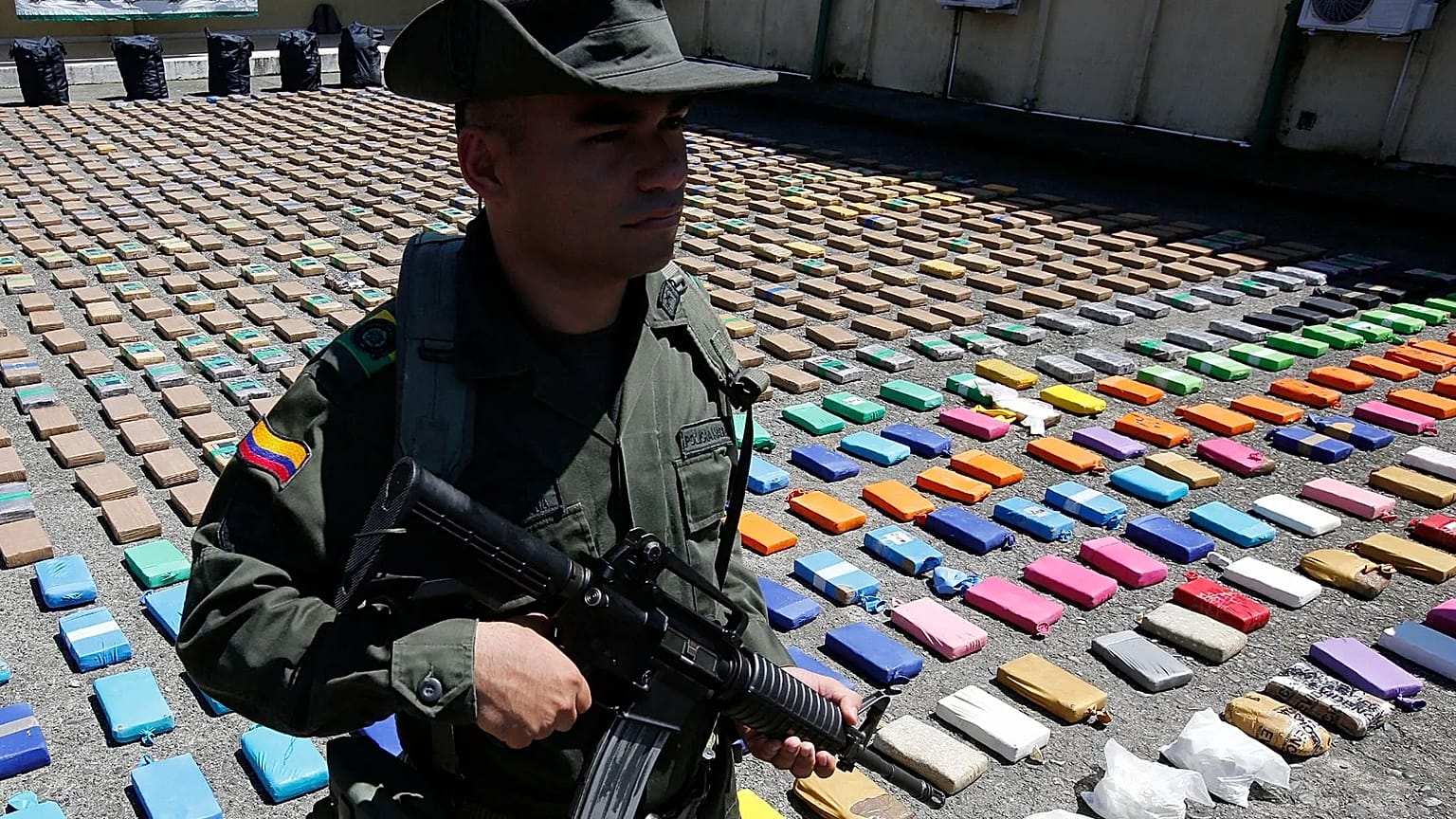A police officer stands guard over packages of seized cocaine during a media presentation at the pacific port of Buenaventura, 10 August, 2017