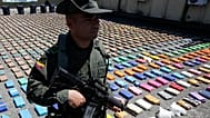 A police officer stands guard over packages of seized cocaine during a media presentation at the pacific port of Buenaventura, 10 August, 2017