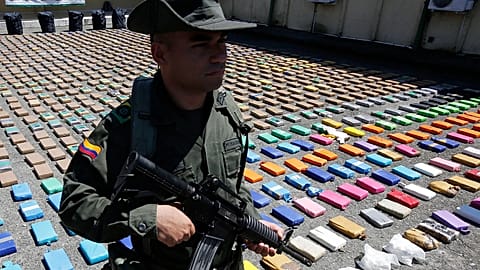A police officer stands guard over packages of seized cocaine during a media presentation at the pacific port of Buenaventura, 10 August, 2017