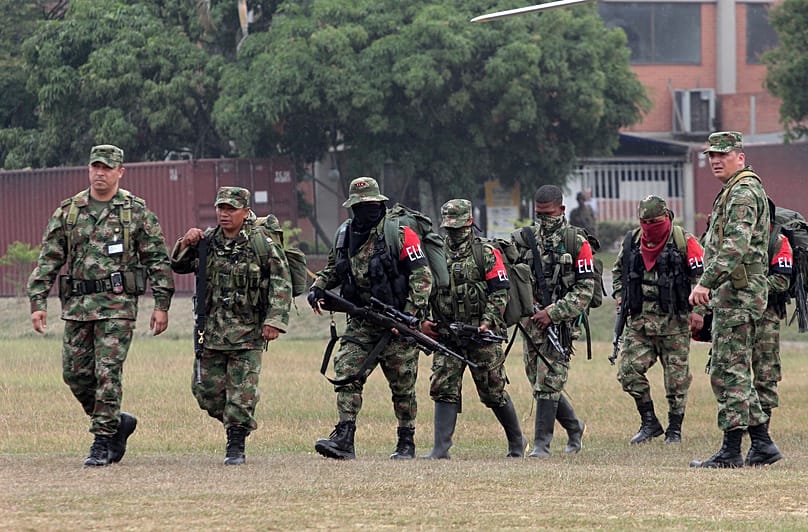 Soldiers escort rebels of the National Liberation Army (ELN) who gave themselves up upon their arrival at a military base in Cali, 16 July, 2013