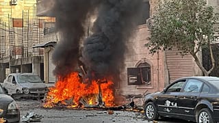 Un'auto brucia durante gli scontri tra i combattenti curdi e le forze governative siriane in una zona contesa di Aleppo, 7 gennaio, 2026