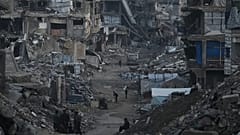 Filistinliler Gazze'de İsrail'in hava ve kara operasyonları sonucu yıkılan binaların arasında yürürken, 6 Ocak 2026