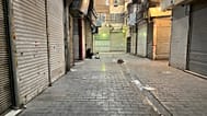 A man sits as shops are closed during protests in Tehran's centuries-old main bazaar, 6 January, 2026