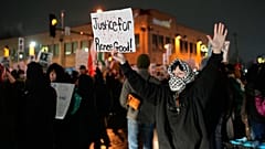 Bei einer Kundgebung für Renee Good hält ein Demonstrant ein Schild. Ein Beamter der US-Behörde ICE erschoss sie am siebten Januar.