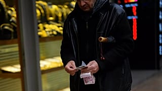 Son 6 aylık enflasyon verisiyle en düşük emekli maaşı 18 bin 938 TL'ye olmuştu. / İstanbul Eminönü'ndeki bir döviz bürosunun önünde para sayan bir adam / 25 Ocak 2024.