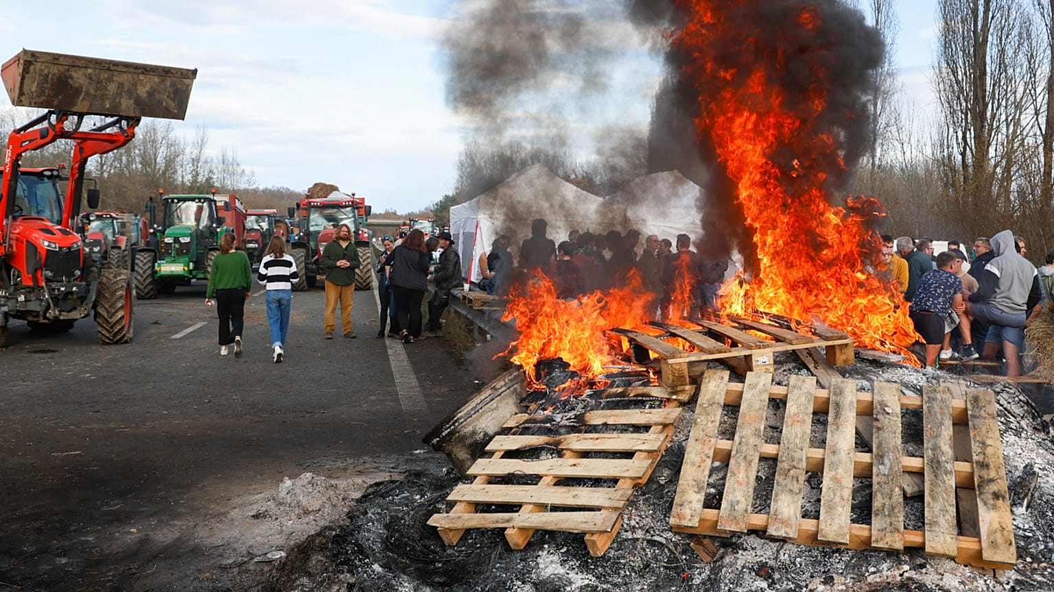 French farmers gather around a fire near Urt, southwestern France, to protest against a mass cull of cows ordered to contain the spread of a skin disease, 15 December 2025.