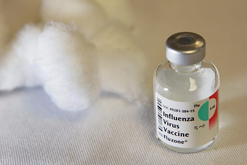 A vial that contained a dose of seasonal flu vaccine is seen on a table with cotton balls where flu shots were being administered in Boston Thursday, Oct. 1, 2009.