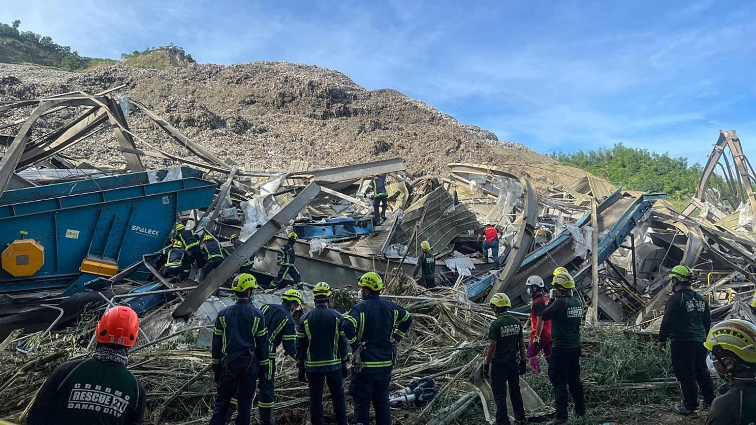 Kurtarma görevlileri yıkılan çöp sahasında.