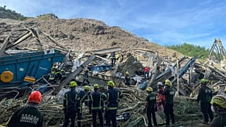 Kurtarma görevlileri yıkılan çöp sahasında.