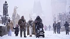 Menschen überqueren die mittelalterliche Karlsbrücke während eines starken Schneefalls in Prag, 9. Januar 2026