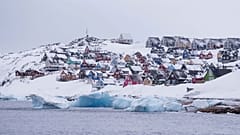 Bunte, schneebedeckte Häuser sind vom Meer aus in Nuuk, Grönland, am 6. März 2025 zu sehen. 