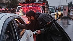 ضابط في القوات السورية يدقّق في هويات سكان يفرّون من حيّ الشيخ مقصود في حلب، سوريا، الجمعة 9 يناير/كانون الثاني 2026.