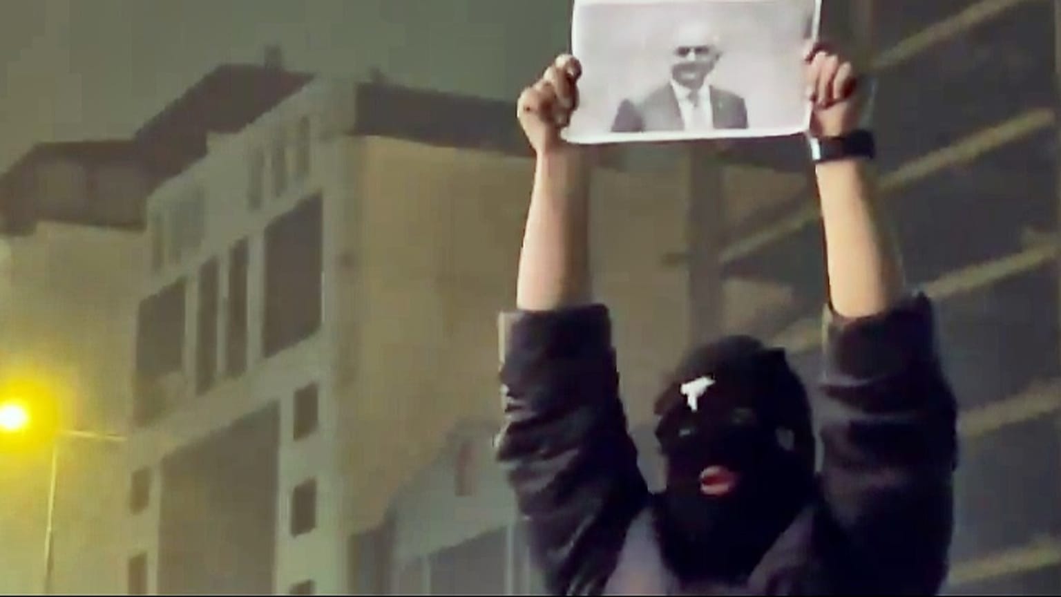 Zamaskowany demonstrant trzyma zdjęcie irańskiego księcia Reza Pahlavi podczas protestu w Teheranie, Iran, piątek, styczeń. 9, 2026