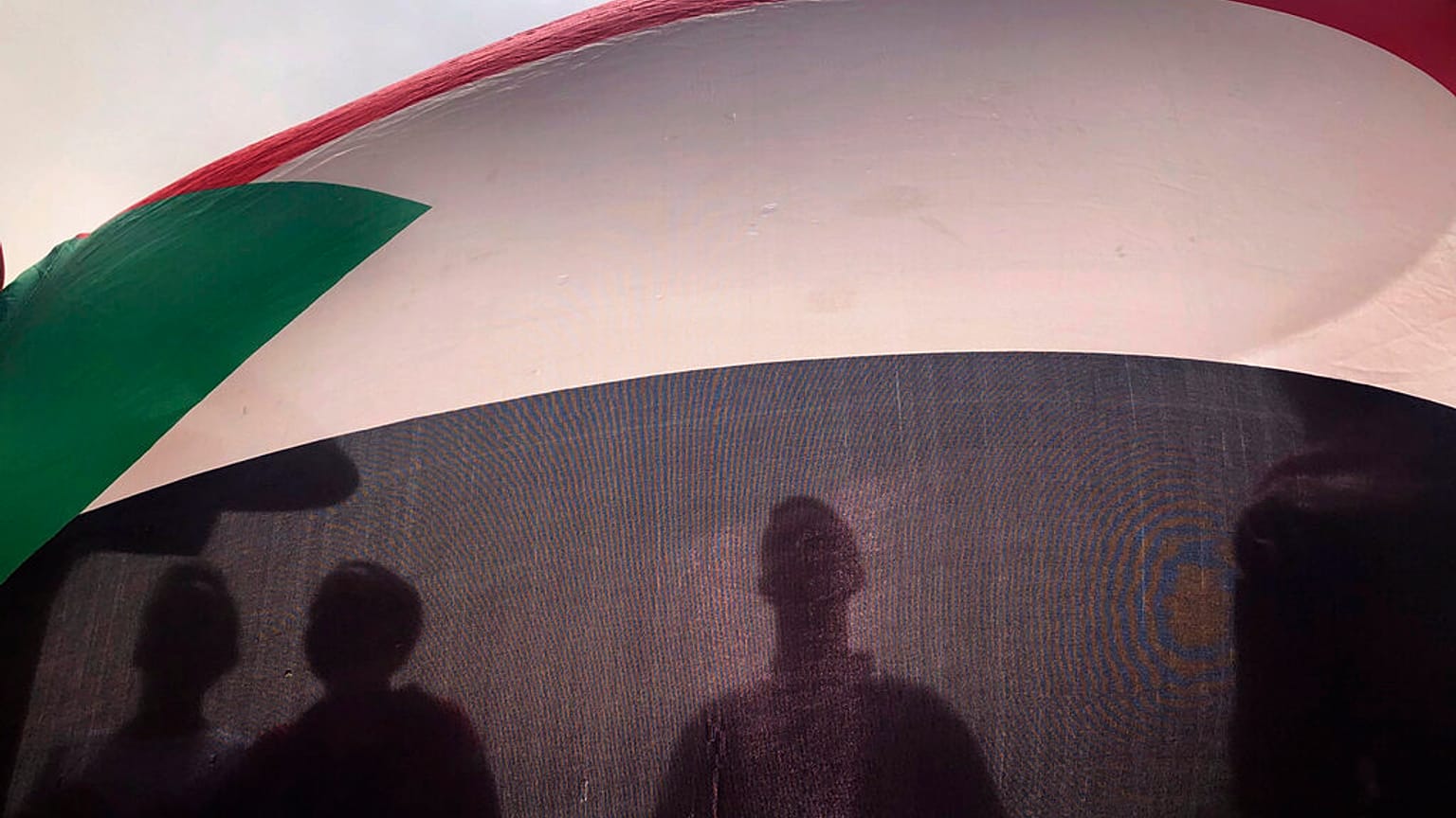  30 يونيو/حزيران 2019، يظهر متظاهرون سودانيون وهم يرفعون علم بلادهم خلال مسيرة احتجاجية ضد المجلس العسكري الحاكم في الخرطوم، السودان. 