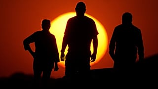 People watch the sunset from the Liberty Memorial grounds in Kansas City, Mo., May 12, 2025.