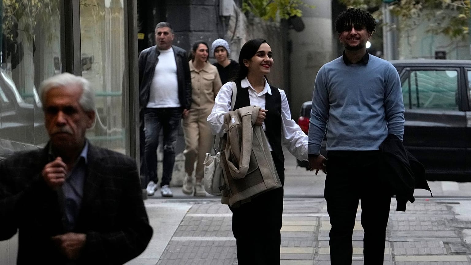 eople walk on a sidewalk in northern Tehran, Iran