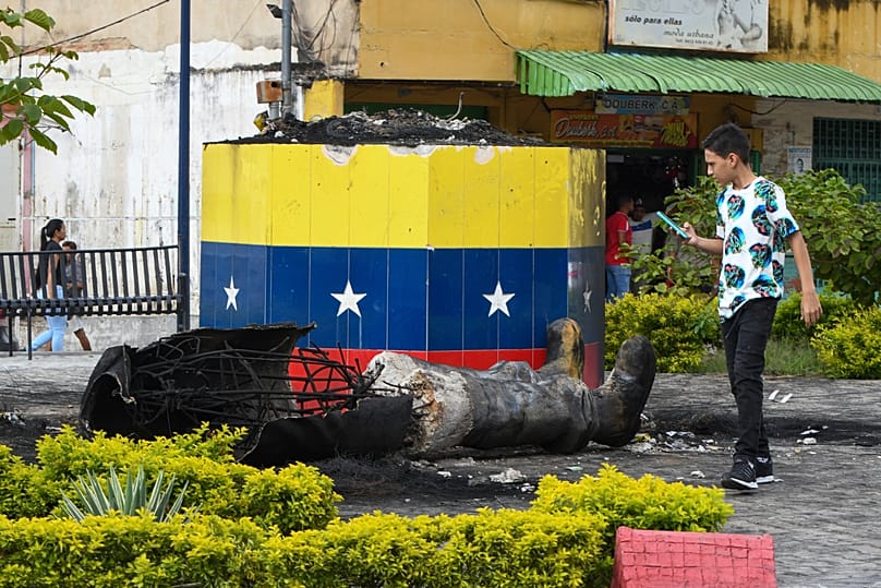 A destroyed statue of the late Venezuelan President Hugo Chávez lies next to its base in Valencia, 31 July, 2024