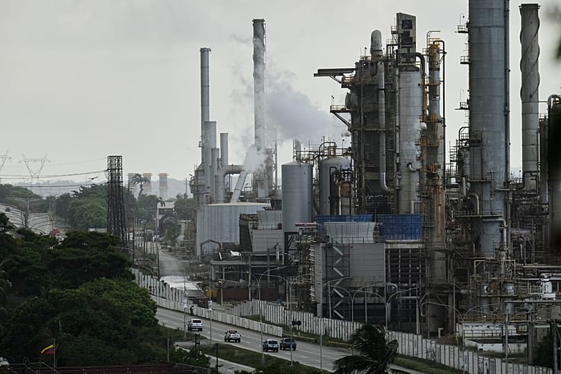 Vehicles drive past the El Palito oil refinery in Puerto Cabello, 21 December, 2025