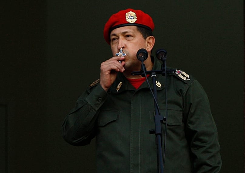 Venezuelan President Hugo Chávez kisses a crucifix as he greets supporters from the presidential palace in Caracas, 4 July, 2011