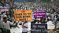 Rohingya refugees carry banners during a visit by the UN Secretary General at a camp in Cox's Bazar, 14 March, 2025