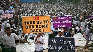Rohingya refugees carry banners during a visit by the UN Secretary General at a camp in Cox's Bazar, 14 March, 2025