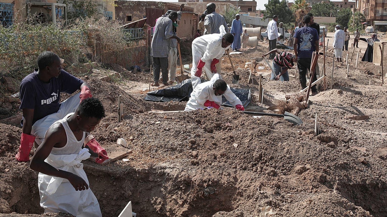 أعضاء الهلال الأحمر السوداني يعيدون دفن رفات ضحايا النزاع الذي استمر عامين في السودان، وينقلون الجثث من مقابر مؤقتة إلى مقبرة محلية في الخرطوم، السودان، الأحد 11 يناير 2026.