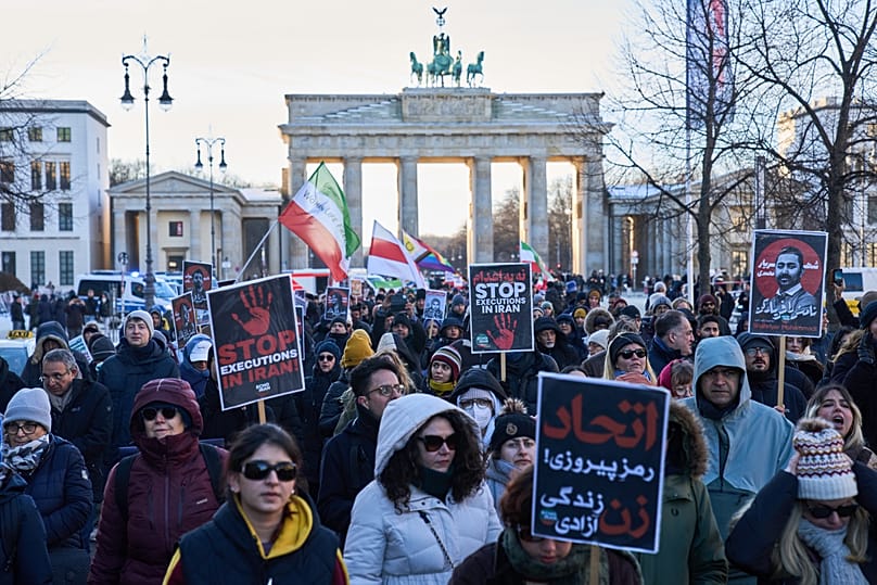 Des manifestants participent à une manifestation devant la porte de Brandebourg à Berlin, le 11 janvier 2026.