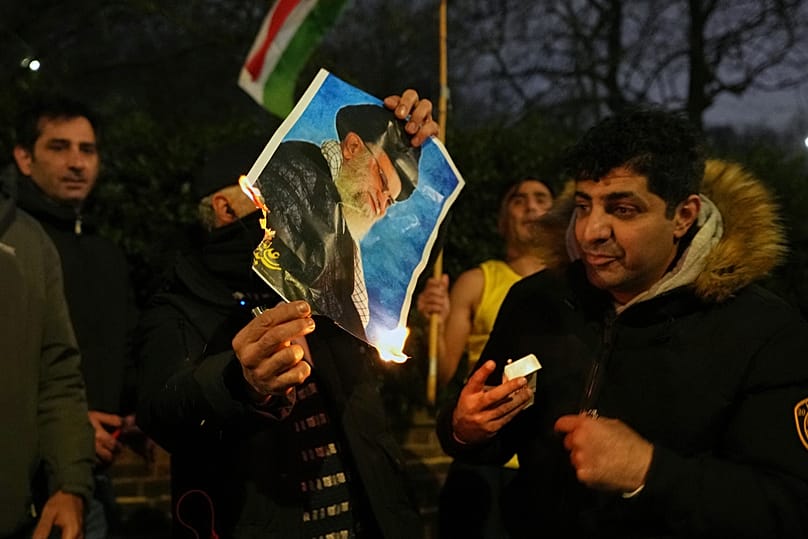 A picture of Ayatollah Ali Khamenei is set alight by protesters outside the Iranian Embassy in London, Monday, Jan. 12, 2026.