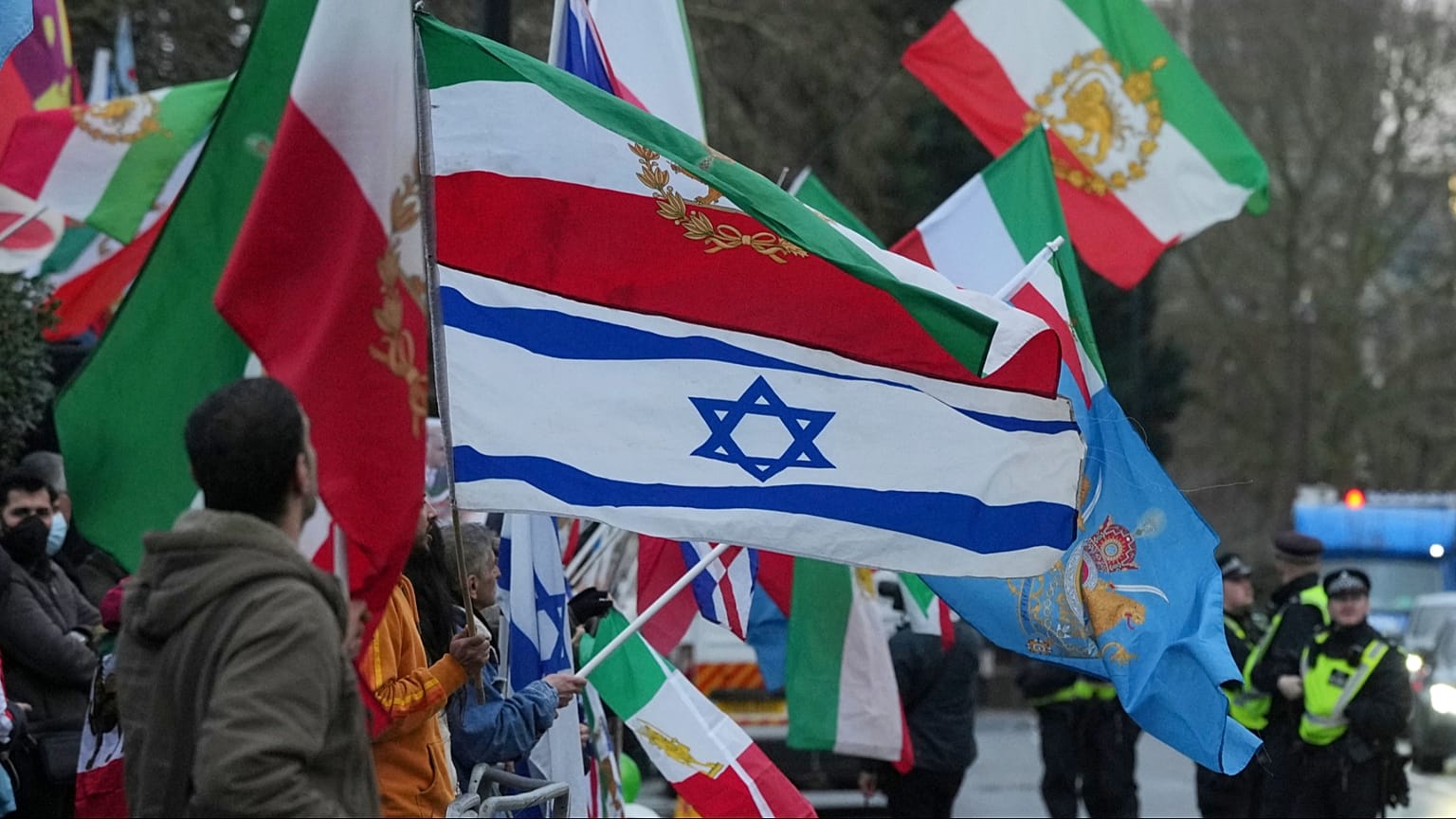معترضان با پرچم‌ و پلاکارد در دست، از جمله پرچم اسرائیل، در مقابل سفارت ایران در لندن، دوشنبه، ۱۲ ژانویه ۲۰۲۶