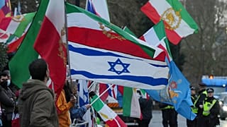 معترضان با پرچم‌ و پلاکارد در دست، از جمله پرچم اسرائیل، در مقابل سفارت ایران در لندن، دوشنبه، ۱۲ ژانویه ۲۰۲۶